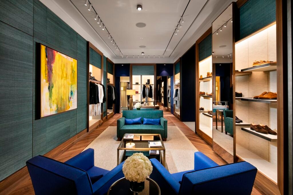 Overall view of Kiton flagship store with blue and green color scheme with shoppers sitting areas